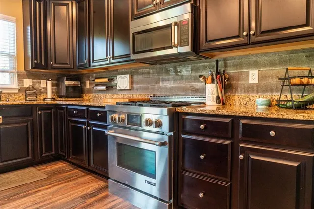 a kitchen with granite countertop stainless steel appliances and wooden cabinets