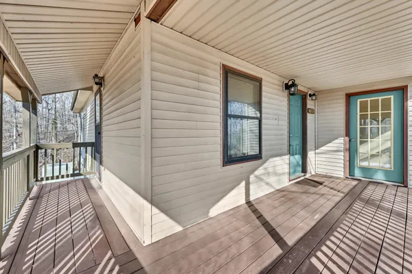 a view of kitchen and empty room with wooden floor