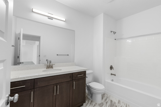 43 South Crimson Way, Unit 311 Mapleton, UT 84664 - Photo 21 of 28 Bathroom featuring a dark wood-finish vanity with a light speckled countertop, under-mount sink, and brushed nickel faucet