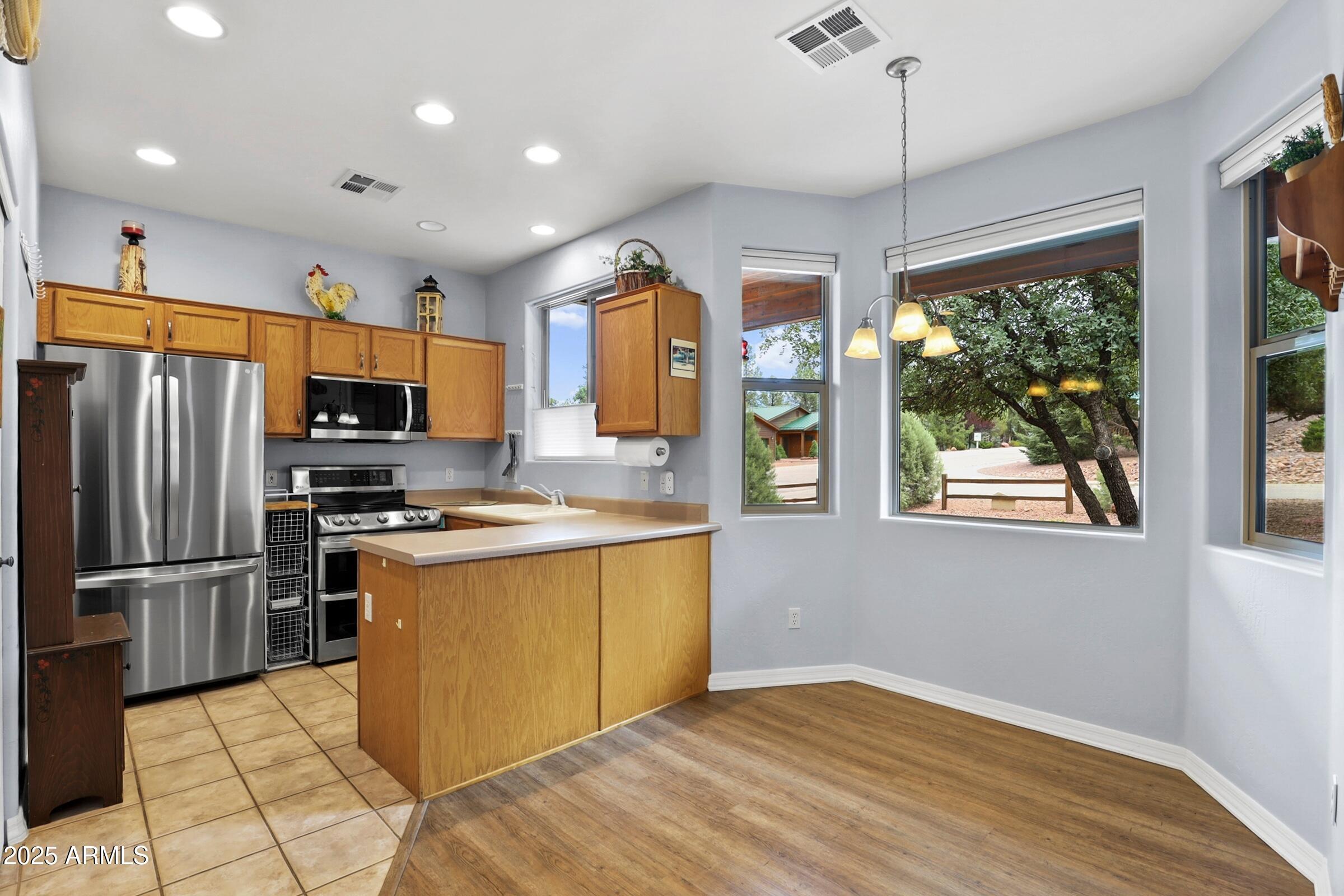 300 West Cody Circle Payson, AZ 85541 - Photo 14 of 25 a kitchen with stainless steel appliances granite countertop a refrigerator a stove top oven a sink dishwasher and wooden cabinets
