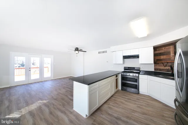 a kitchen with stainless steel appliances granite countertop a stove a sink and a refrigerator