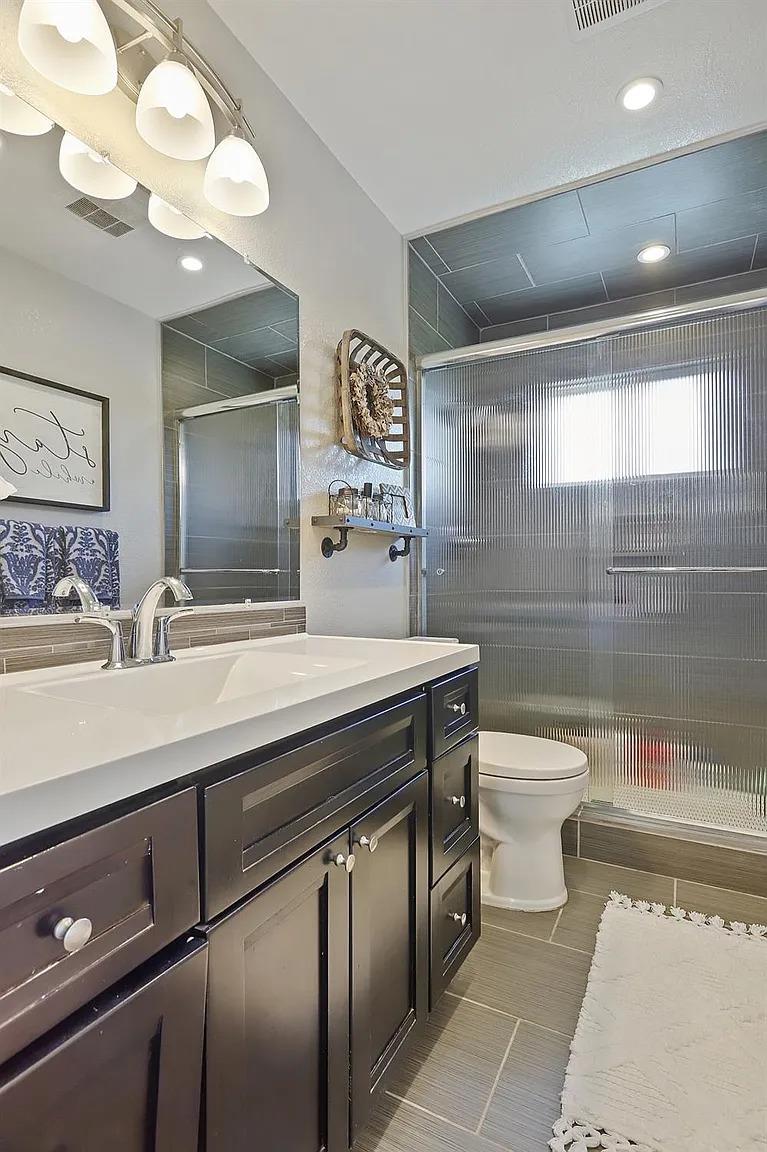 18393 Paradise Road Tracy, CA 95304 - Photo 9 of 35 a bathroom with a sink a toilet and a mirror