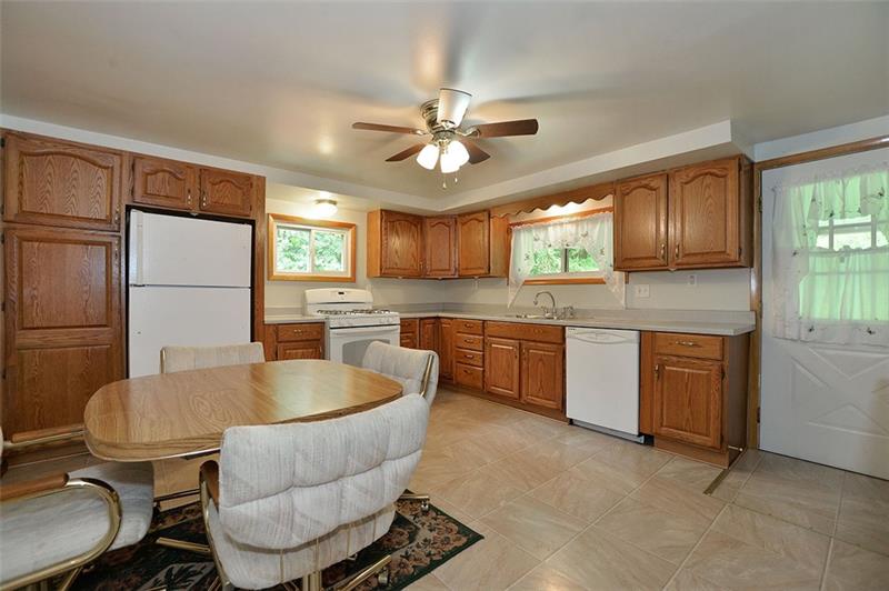 117 Landell Street Rochester, PA 15074 - Photo 5 of 19 Plenty of cabinets in the equipped kitchen. The door opens to the covered rear porch.