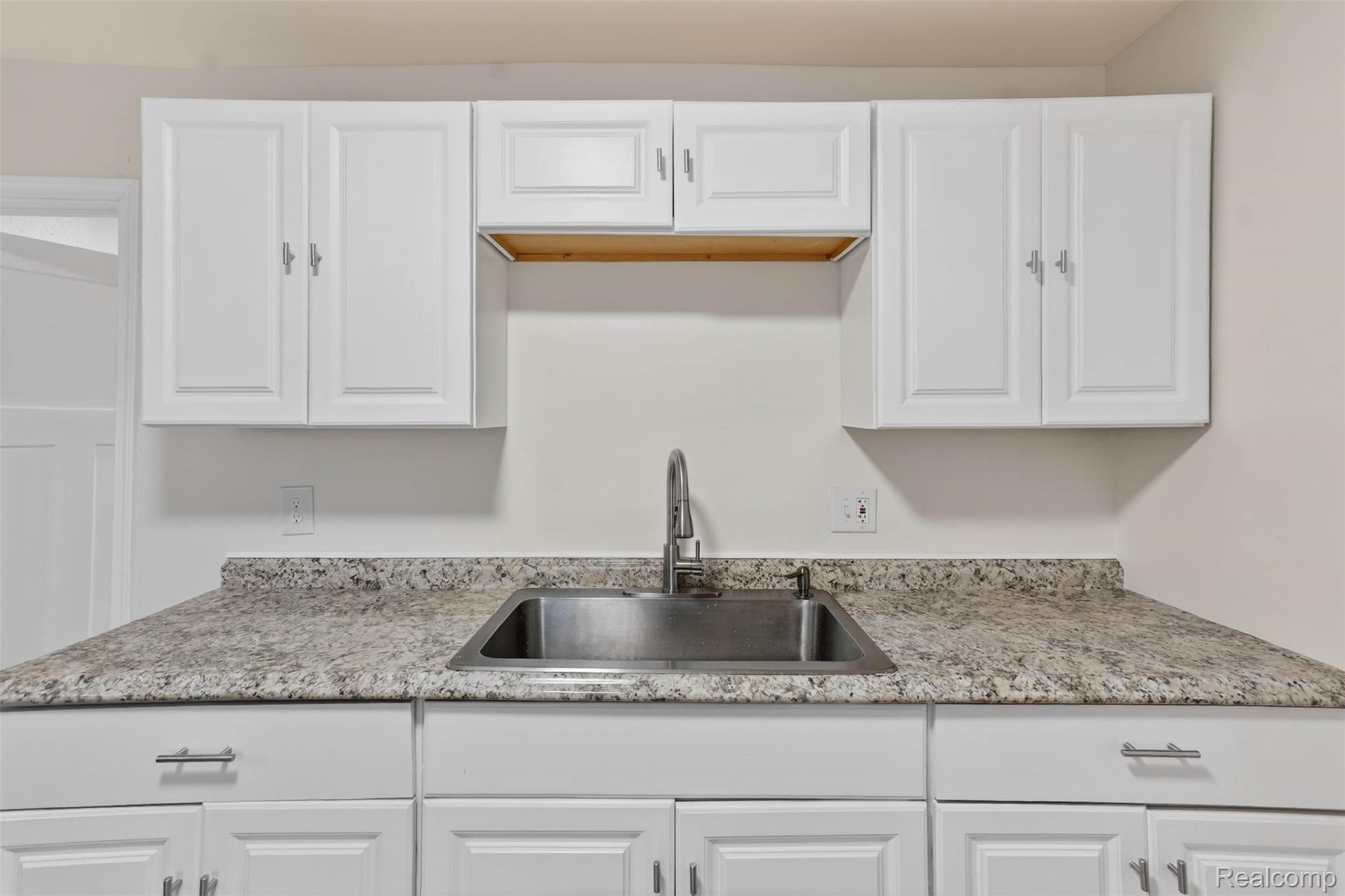 4910 Hughes Road Lansing, MI 48910 - Photo 15 of 27 Kitchen with white cabinetry and light stone countertops