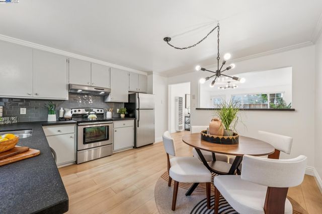 a kitchen with stainless steel appliances kitchen island granite countertop a sink and chairs