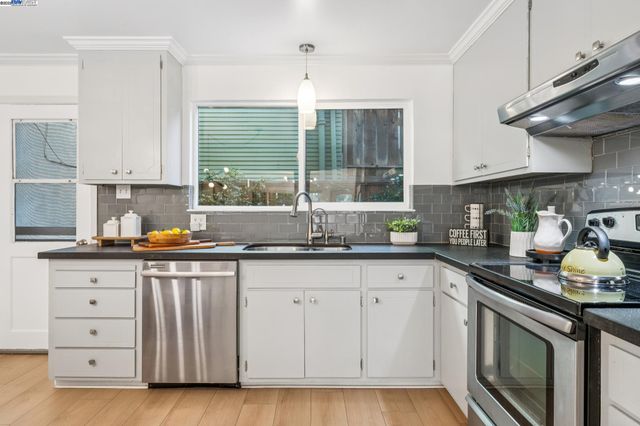 a kitchen with granite countertop white cabinets and a sink