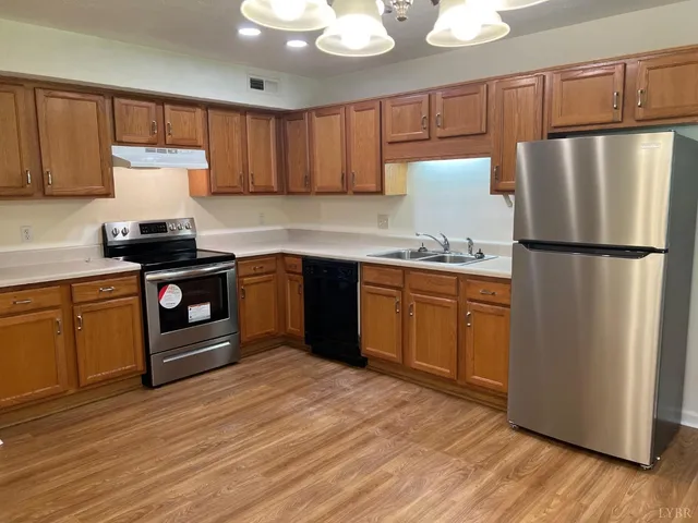 a kitchen with a refrigerator sink and cabinets