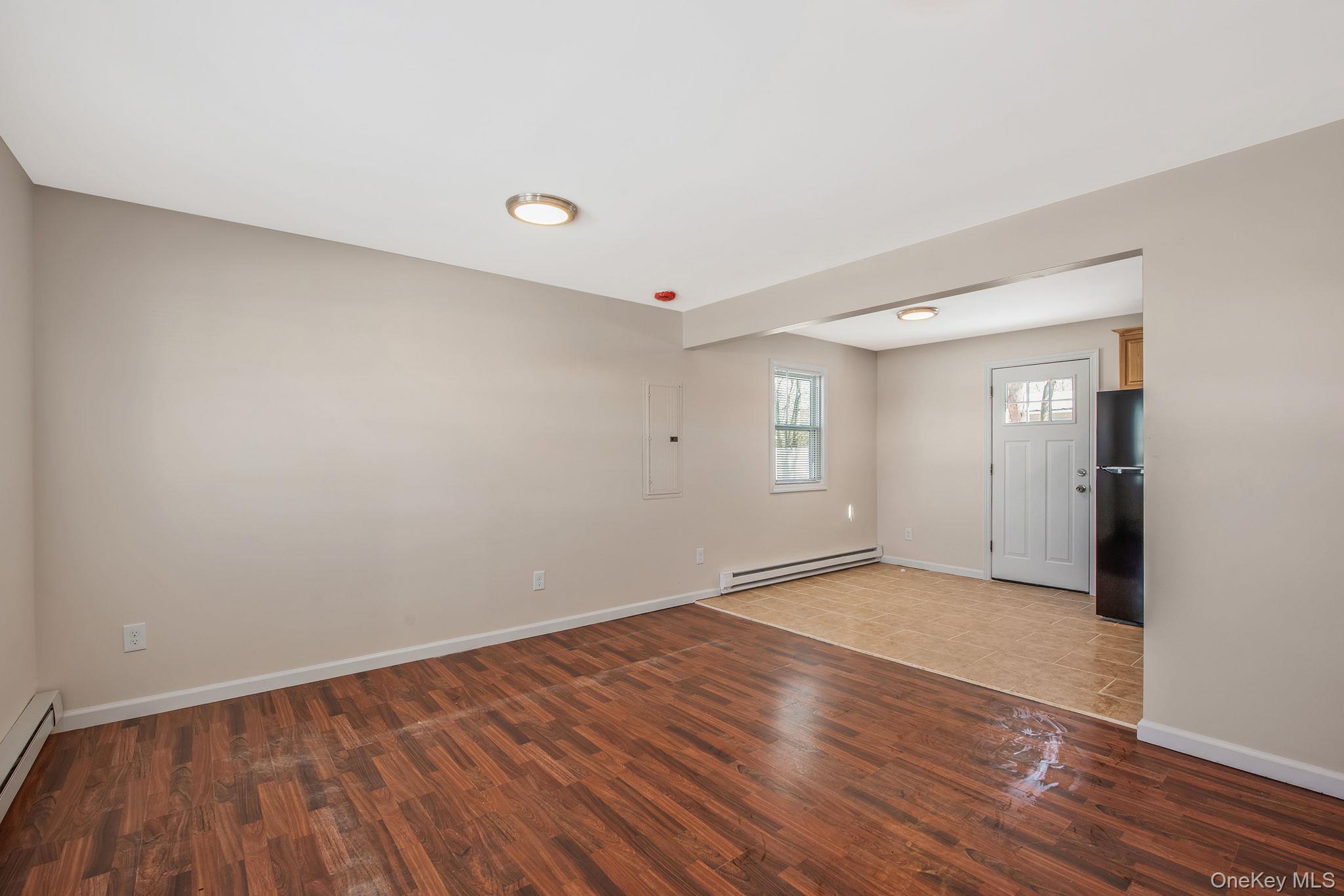 703 Provost Avenue Bellport, NY 11713 - Photo 1 of 16 a view of an empty room with wooden floor and a window