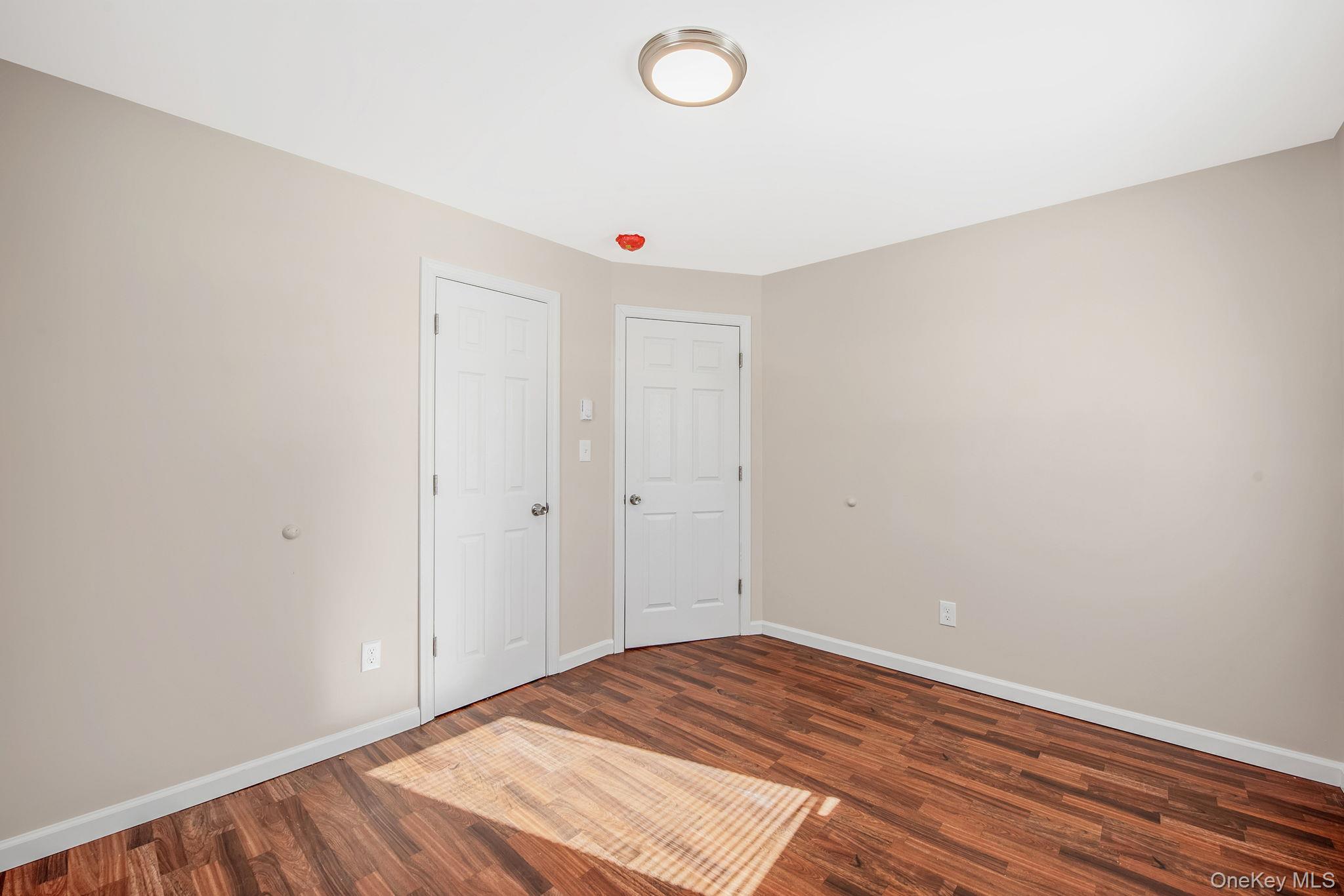 703 Provost Avenue Bellport, NY 11713 - Photo 13 of 16 a view of a room with wooden floor and white walls
