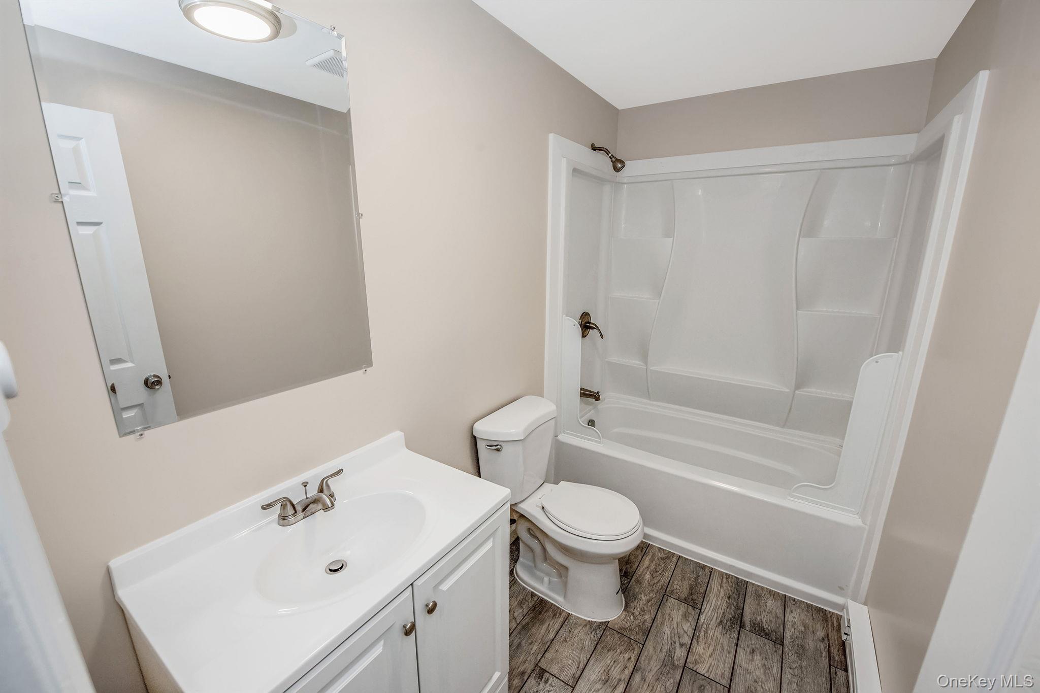 703 Provost Avenue Bellport, NY 11713 - Photo 16 of 16 a bathroom with a sink toilet and shower
