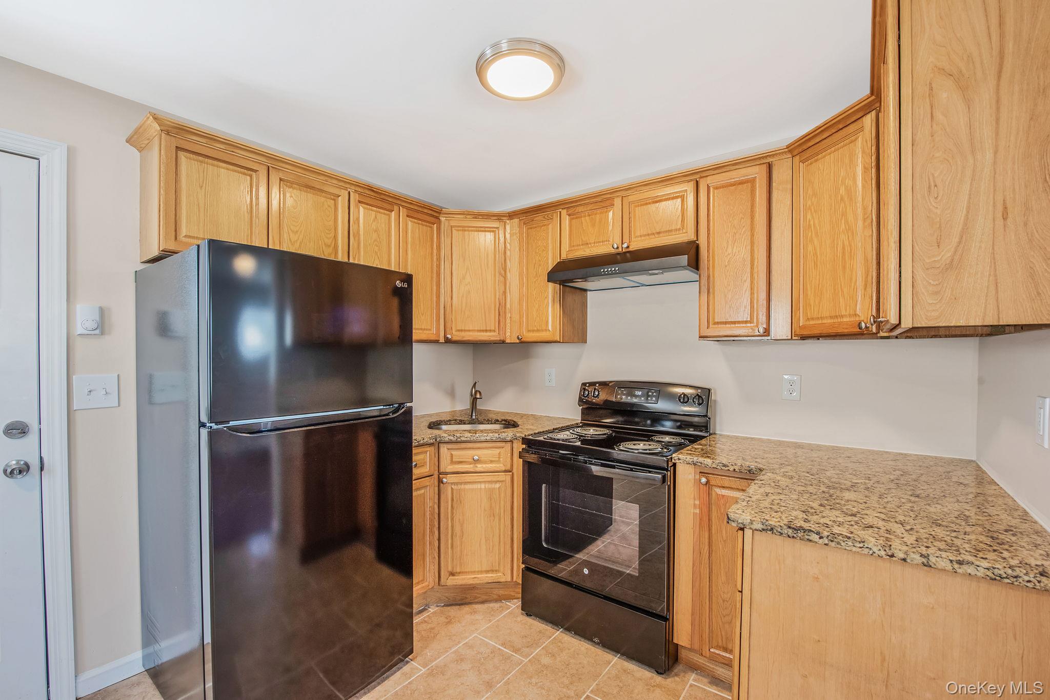 703 Provost Avenue Bellport, NY 11713 - Photo 6 of 16 a kitchen with a stove a refrigerator and a sink