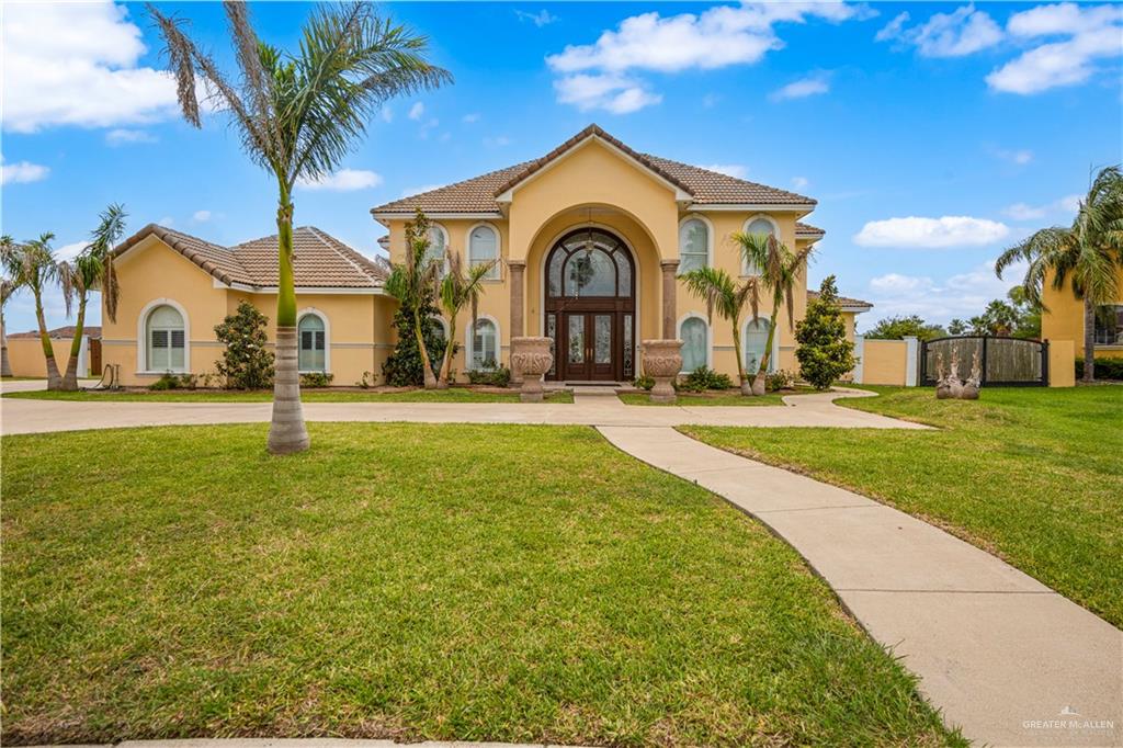 Mediterranean / spanish-style home featuring a tiled roof, a front lawn, french doors, and stucco siding