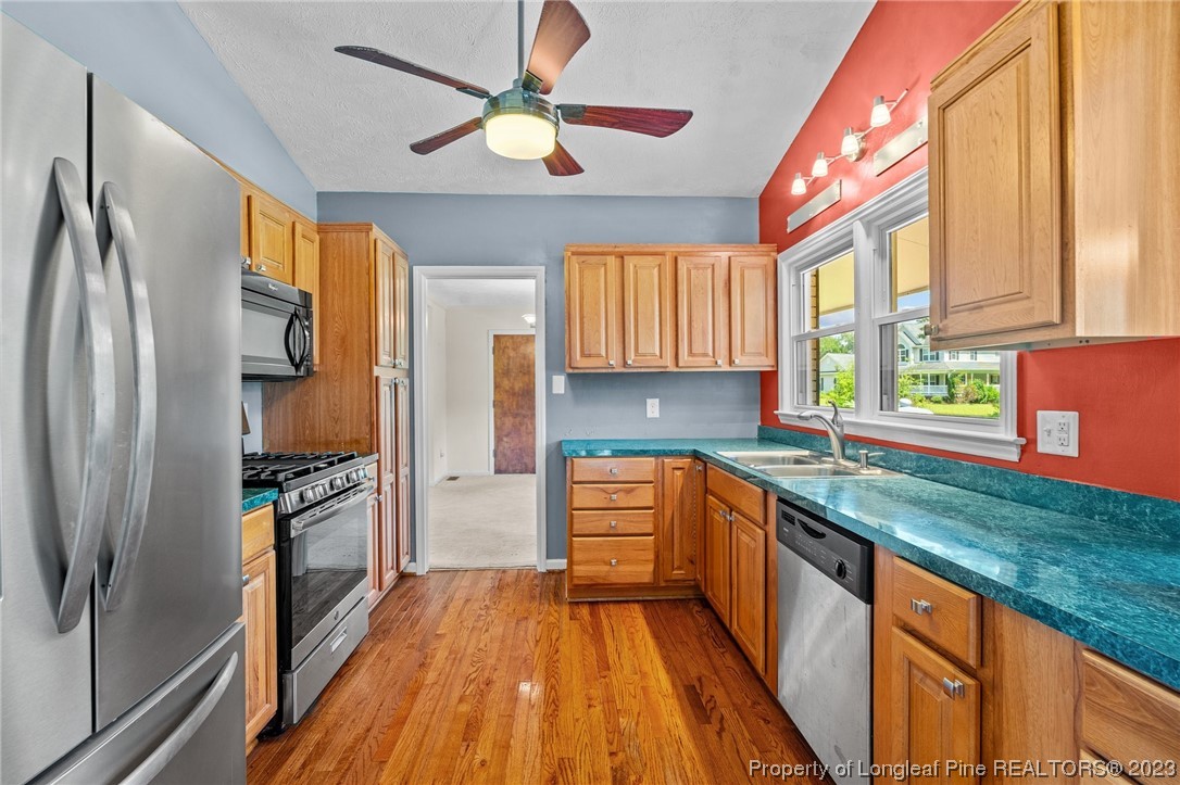 1812 Bainbridge Road Stedman, NC 28391 - Photo 16 of 30 a kitchen with stainless steel appliances granite countertop a refrigerator a sink dishwasher a stove and white countertops with wooden floor
