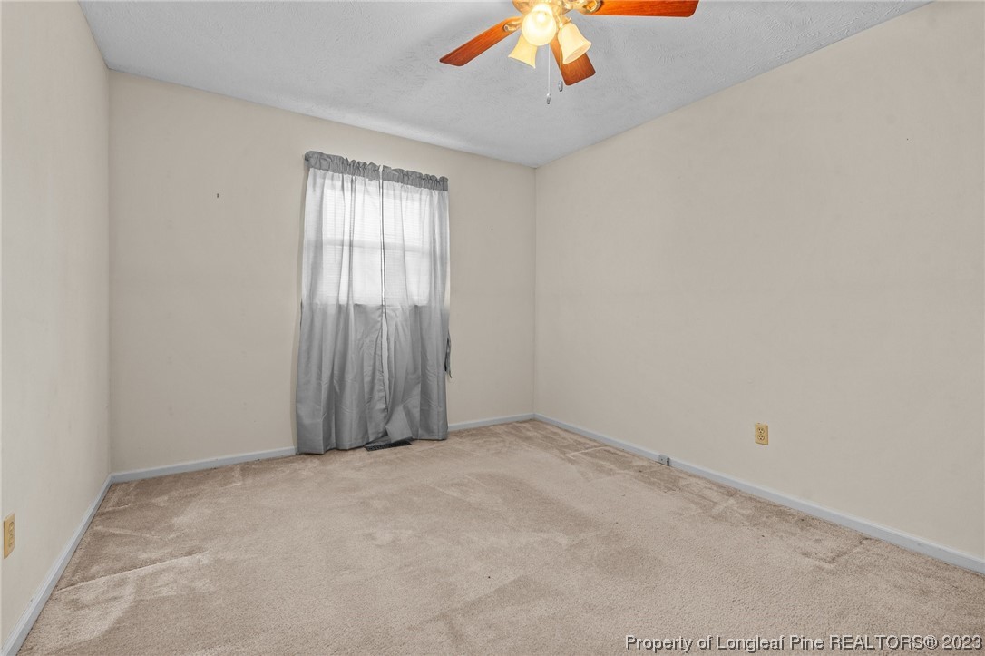 1812 Bainbridge Road Stedman, NC 28391 - Photo 24 of 30 an empty room with a chandelier fan
