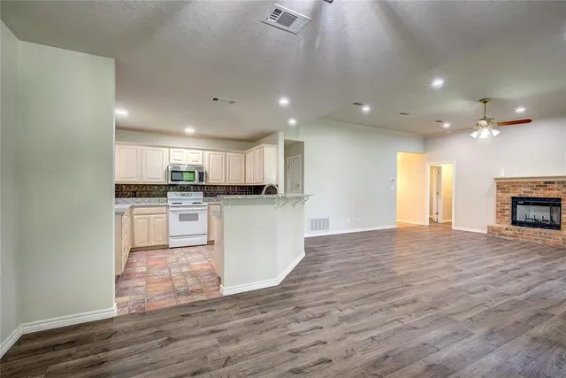 a view of kitchen with granite countertop cabinets and refrigerator