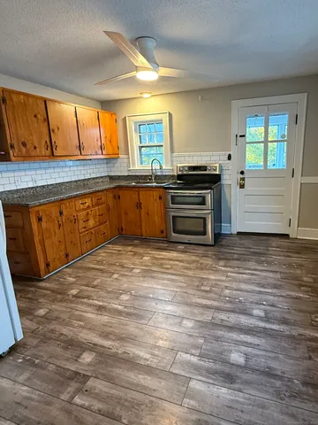 a kitchen with stainless steel appliances kitchen island granite countertop a stove a sink and a refrigerator