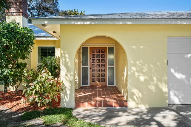 a front view of a house with a garden