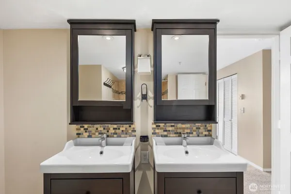 a bathroom with double vanity sink and a mirror