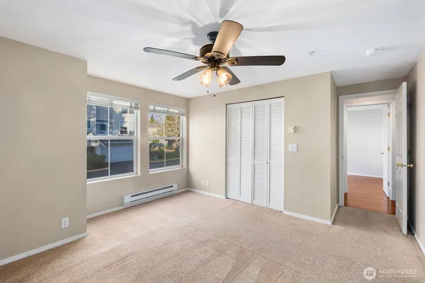 a view of a big room with chandelier fan and windows