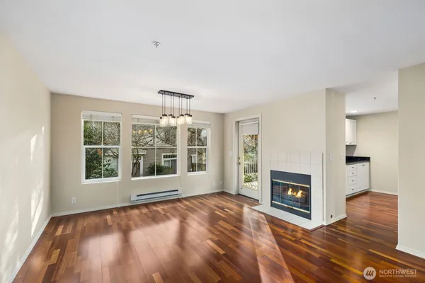 an empty room with windows and fireplace