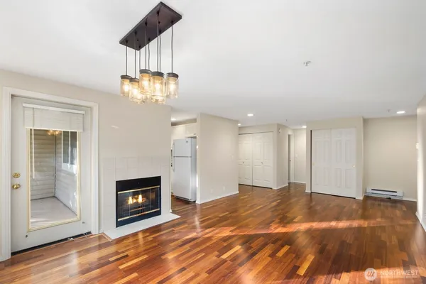 a view of a livingroom with a fireplace a chandelier and wooden floor