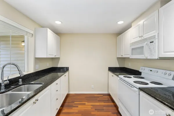 a kitchen that has a sink a stove and cabinets