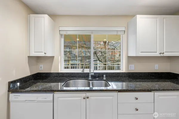 a kitchen with granite countertop a sink and cabinets