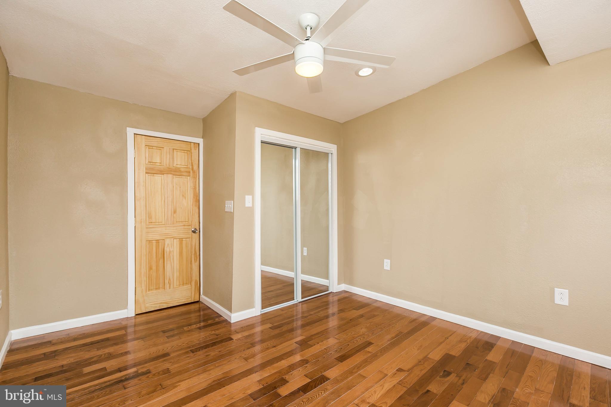 609 Wyeth Street Baltimore, MD 21230 - Photo 22 of 32 an empty room with wooden floor and a ceiling fan
