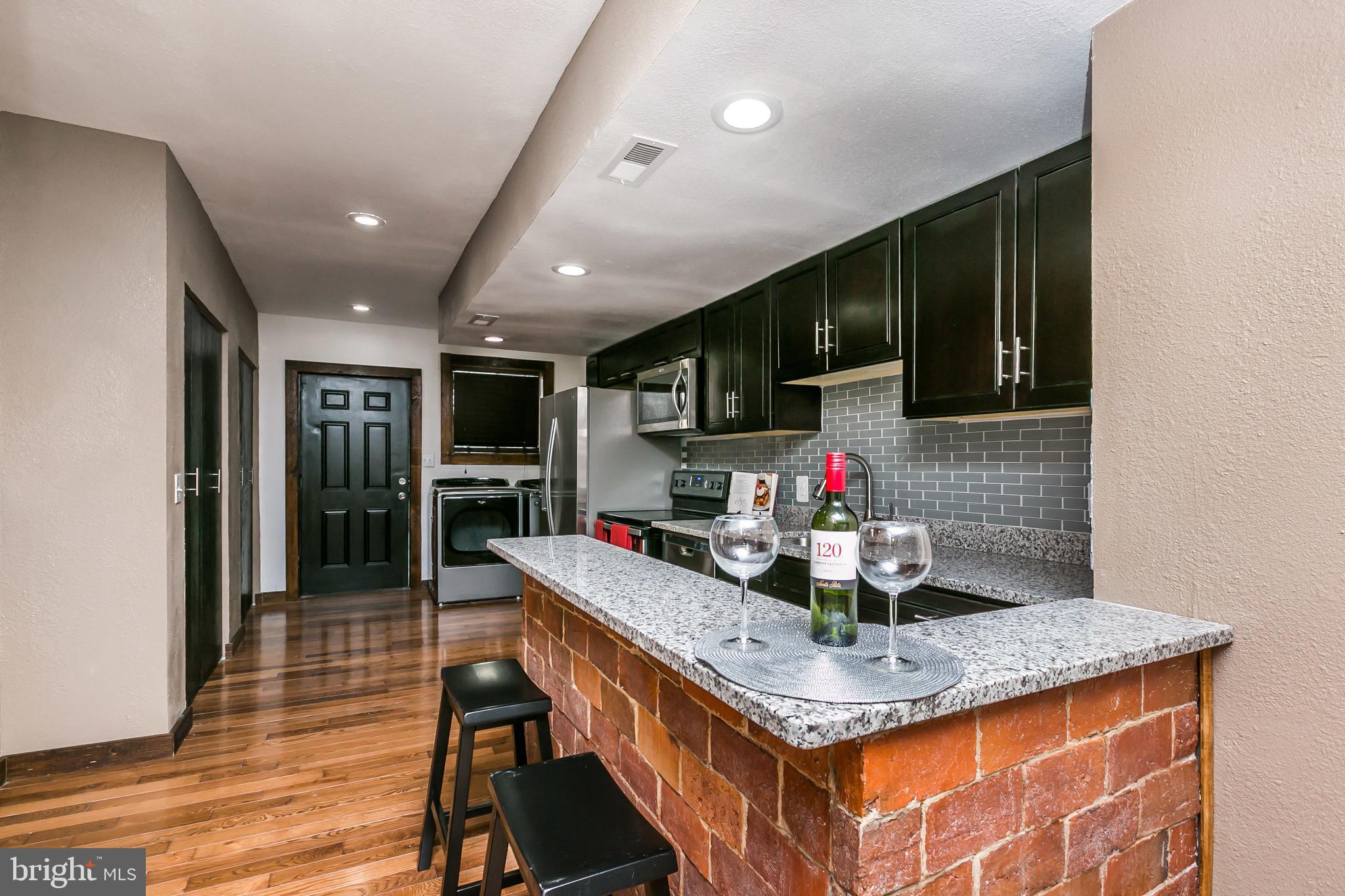 609 Wyeth Street Baltimore, MD 21230 - Photo 6 of 32 a kitchen with stainless steel appliances granite countertop a sink dishwasher a refrigerator and a stove with wooden floor