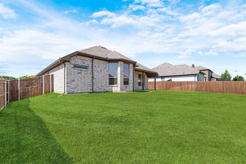 915 Timber Ridge Drive Justin, TX 76247 - Photo 34 of 39 Expansive fenced backyard featuring a substantial lawn area