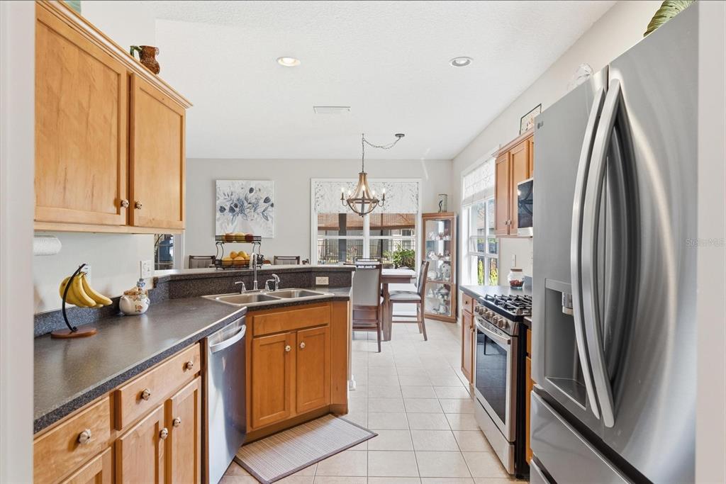 207 Coleton Lane DeLand, FL 32724 - Photo 23 of 65 a kitchen with stainless steel appliances granite countertop a refrigerator a sink a stove and white cabinets
