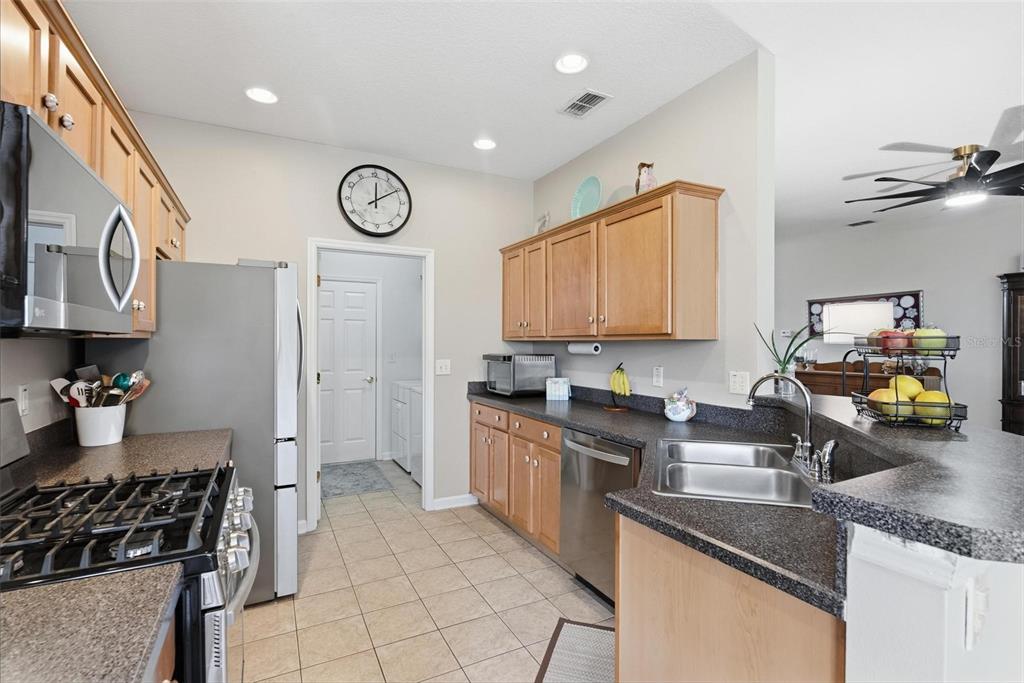 207 Coleton Lane DeLand, FL 32724 - Photo 24 of 65 a kitchen with stainless steel appliances granite countertop a sink stove and cabinets