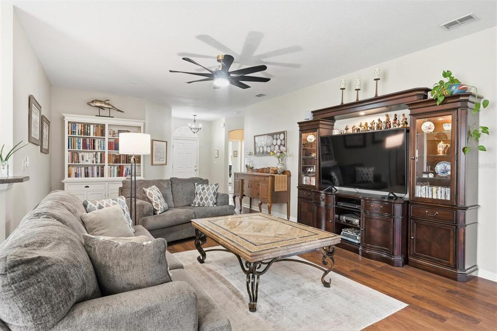 207 Coleton Lane DeLand, FL 32724 - Photo 7 of 65 a living room with furniture a flat screen tv and kitchen view