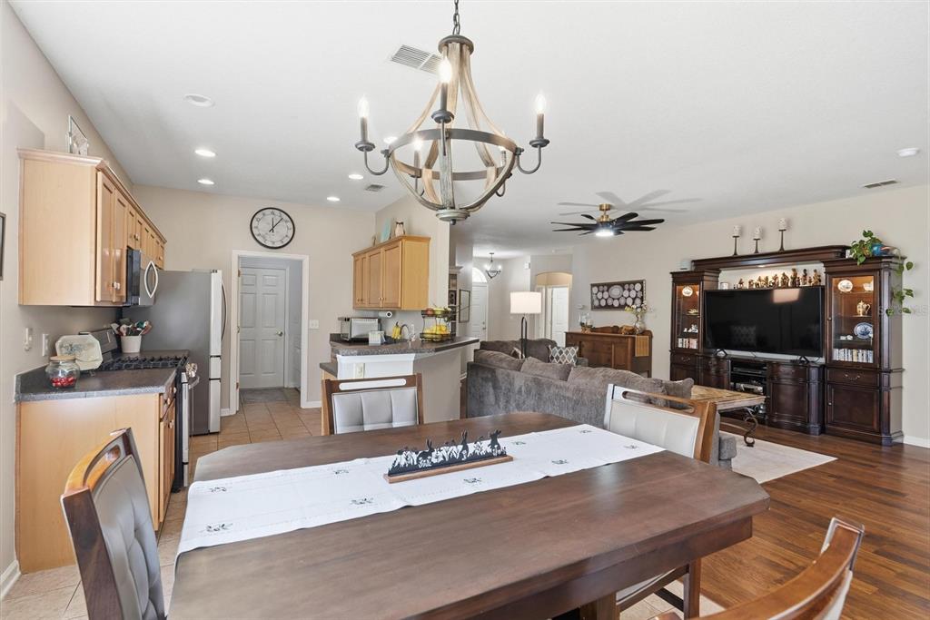 207 Coleton Lane DeLand, FL 32724 - Photo 9 of 65 a view of a dining room with furniture a kitchen and chandelier