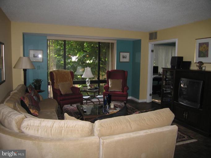 1077 30th Street Northwest, Unit 304 Washington, DC 20007 - Photo 9 of 27 a living room with furniture and a floor to ceiling window