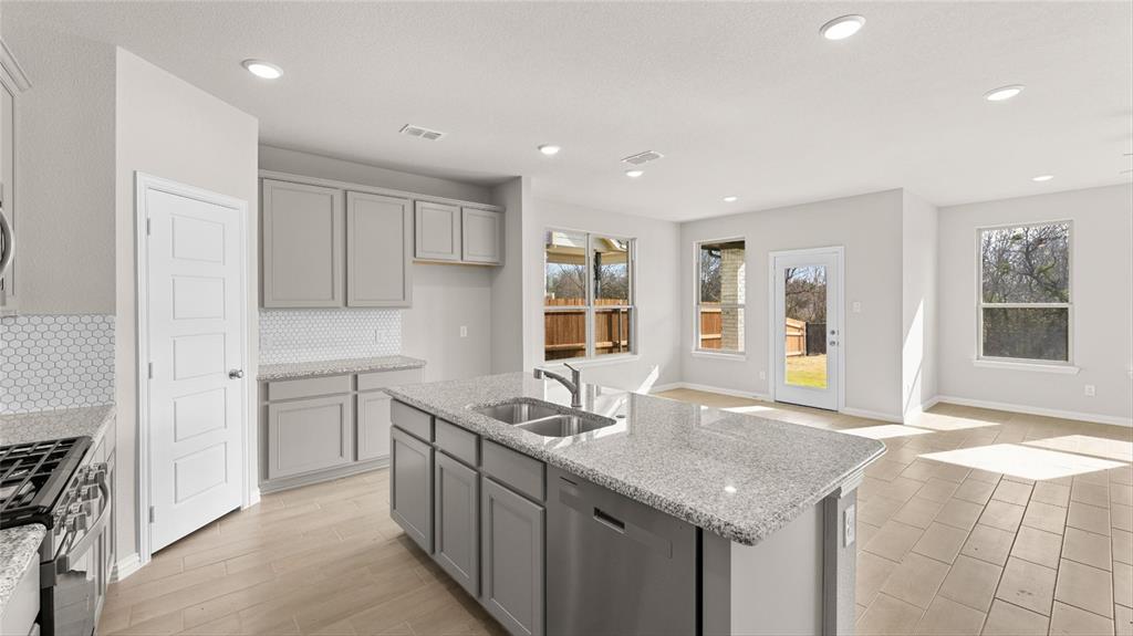 348 Deer Rdg Drive Aledo, TX 76008 - Photo 3 of 15 a kitchen with granite countertop cabinets a sink and a stove