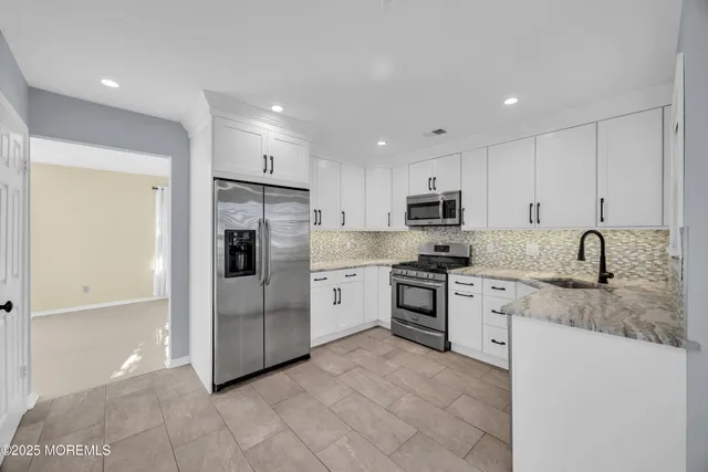 a kitchen with stainless steel appliances granite countertop a refrigerator sink and stove