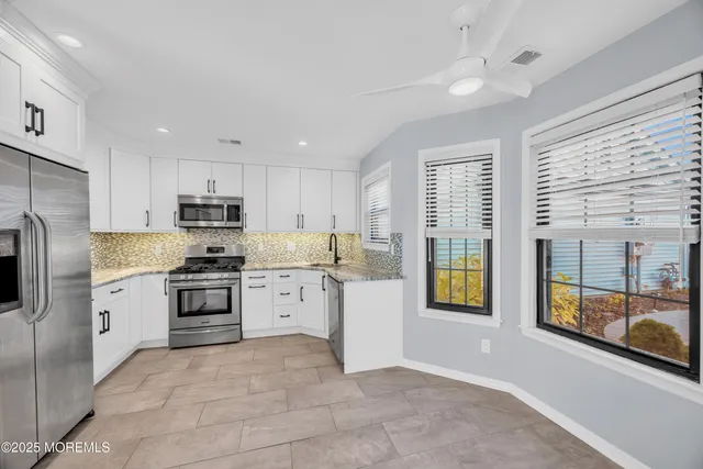 a kitchen with stainless steel appliances a refrigerator sink and cabinets