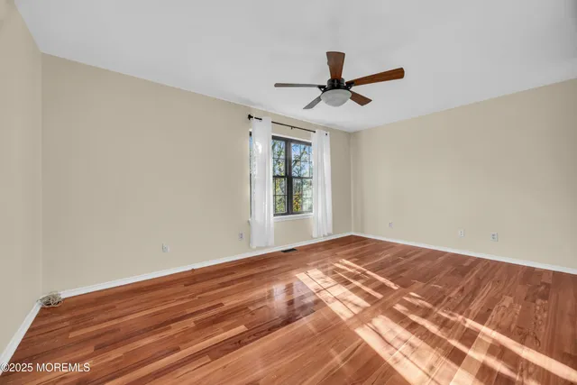a view of a livingroom with a hardwood floor and a ceiling fan
