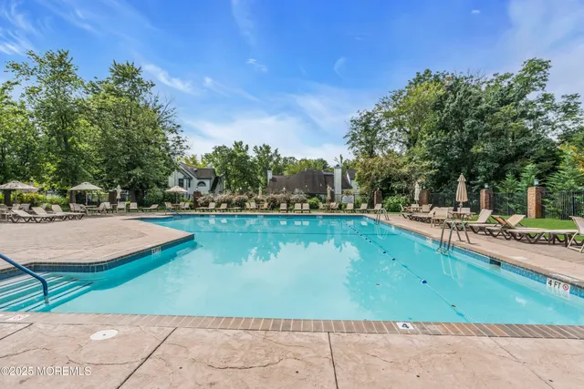 a view of a swimming pool with a yard and sitting area