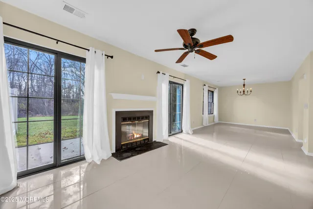 a view of empty room with fireplace and fan