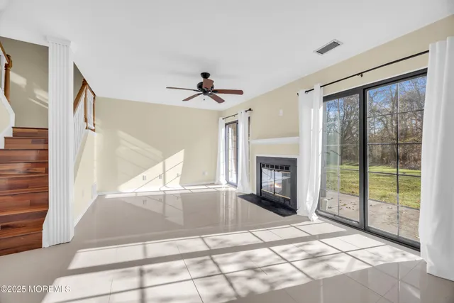 a view of an empty room with windows and fireplace