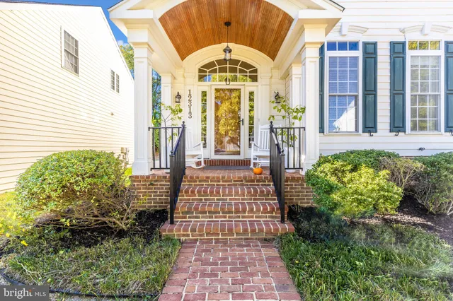 a front view of a house with a lots of flower garden