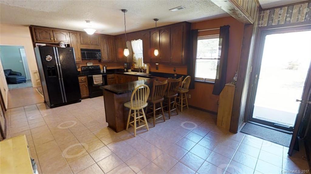 1606 Windsong Forest Road Clover, SC 29710 - Photo 10 of 15 a kitchen with stainless steel appliances granite countertop a refrigerator a sink a stove and a microwave