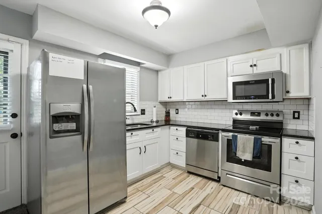 a kitchen with stainless steel appliances granite countertop a stove a refrigerator and a sink