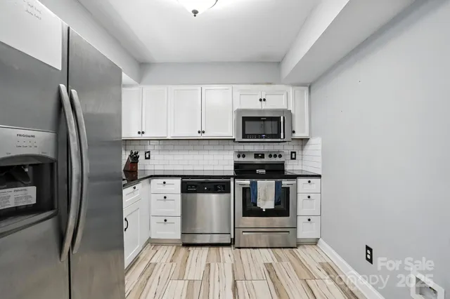 a kitchen with stainless steel appliances a stove a sink and a refrigerator