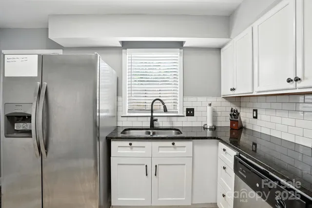 a kitchen with white cabinets and a refrigerator