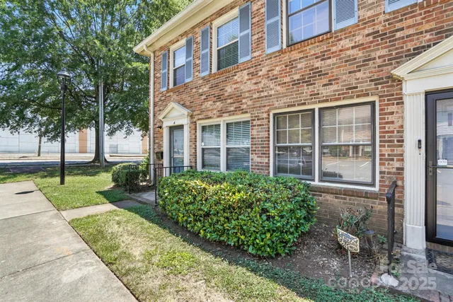 front view of a brick house with a yard