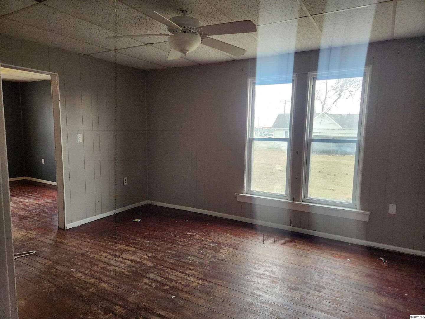 413 South Main Street Loraine, IL 62349 - Photo 3 of 4 an empty room with wooden floor and windows