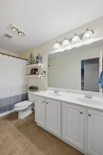 a bathroom with a sink vanity mirror and toilet